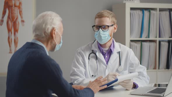 Doctor Meeting with Patient Wearing Protection Mask. Asking for Self-isolation Due To Covid-19