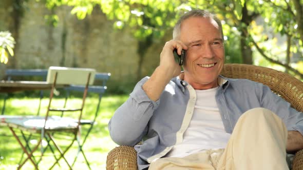 Senior male on phone talking in the garden