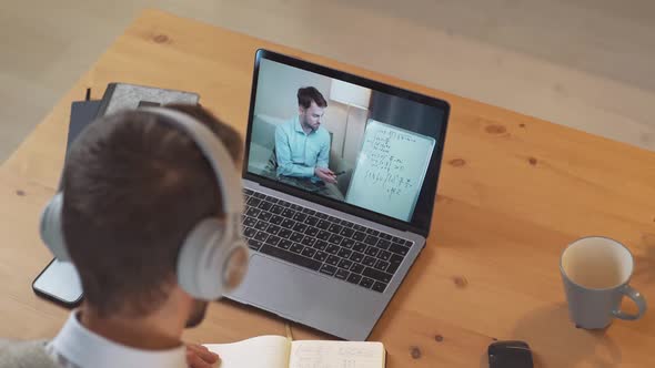 Man Student Sits at a Desk at Home and Study Online Using a Laptop Student Learns in a Remote Lesson