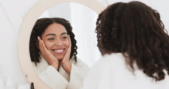 Happy Beautiful Black Lady Looking at Mirror, Smiling To Her Reflection, Enjoying Her Appearance