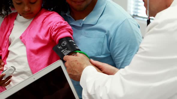 Male doctor checking patient blood pressure