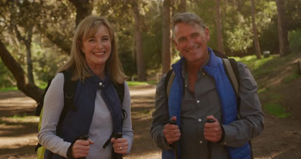 Active senior couple hiking in forest