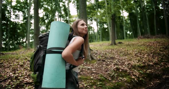 Backpacked Woman Walking in Forest