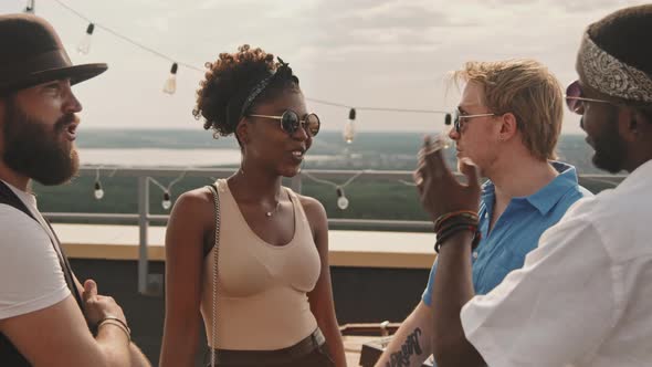 Happy Friends Chatting during Party on Rooftop