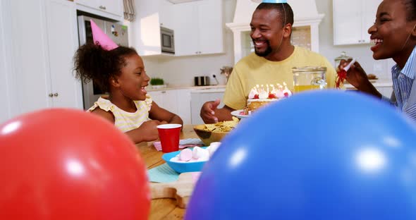 Family celebrating a birthday in kitchen at home