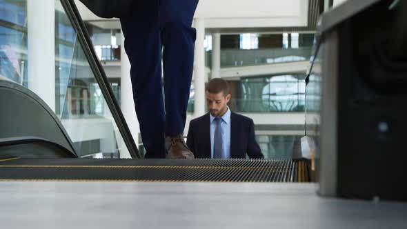 Businessman on the escalator in modern office building