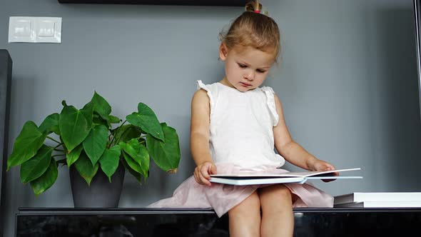 Adorable Toddler Little Girl Reading Book at Home