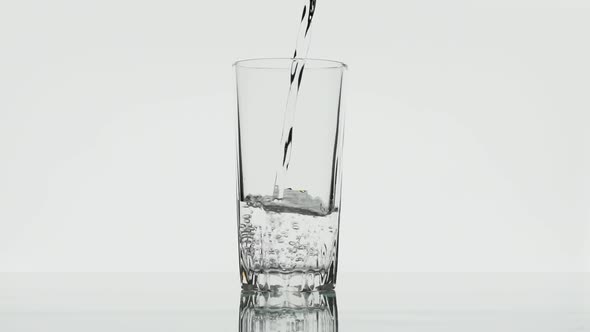 Water is poured into a glass, slow motion