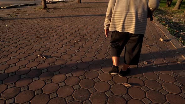 slow-moiton of senior woman legs walking with walking stick in the park