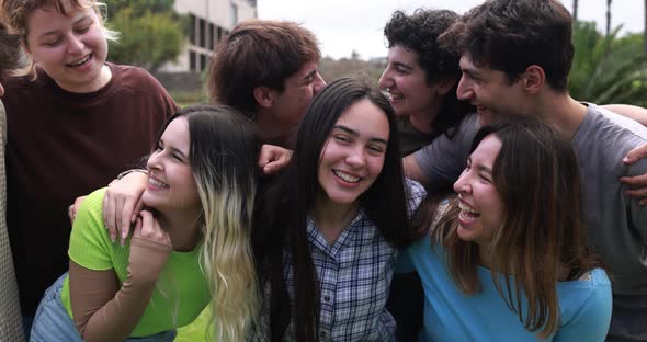 Young group of friends having fun outdoor with university on background