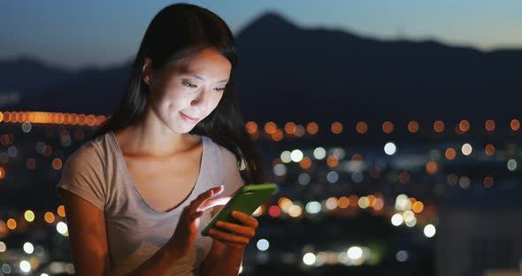 Woman use of mobile phone at night 