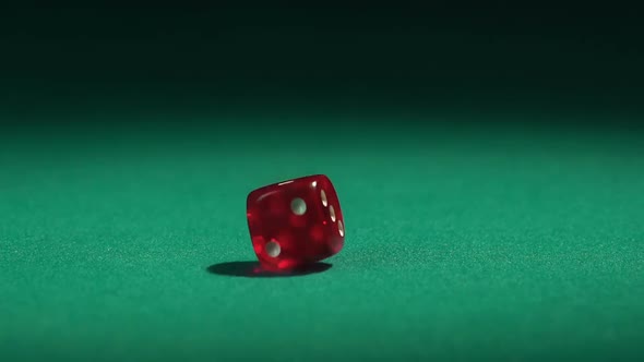 Red dice falling on green table in slow motion. Casino gambling, hobby for rich