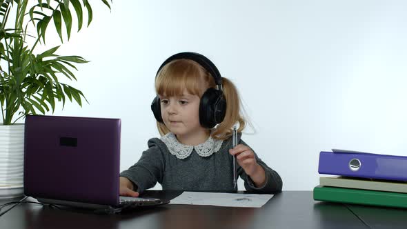 Teen Girl School Student Wearing Wireless Headphones Calling Teacher on Laptop. Distance Education