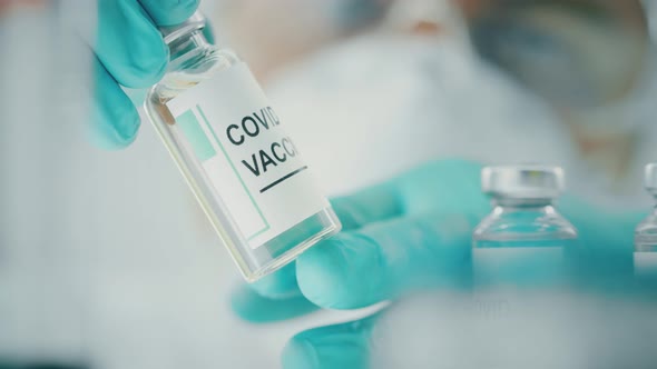 Laboratory Assistant Checks a Vial with COVID19 Vaccine