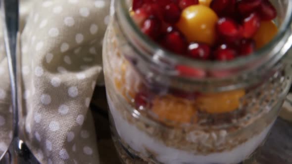 Yogurt with pomegranates and golden berries in glass jar 4k