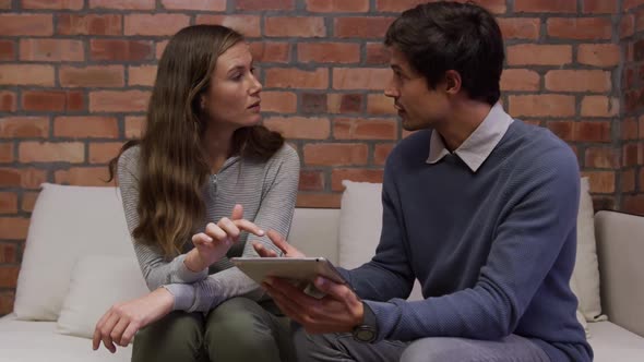 Creative businessman and bussinesswoman discussing over digital table in modern office