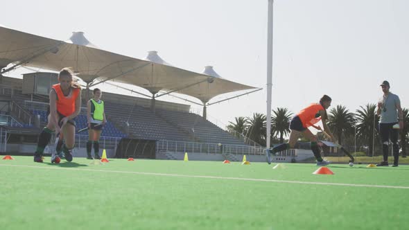 Female hockey players training on a field