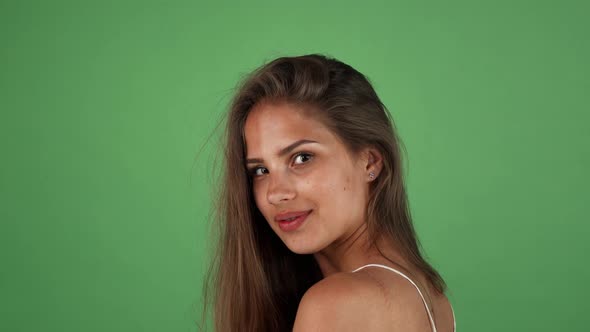 Beautiful Young Long Haired Tanned Woman Smiling Over Her Shoulder