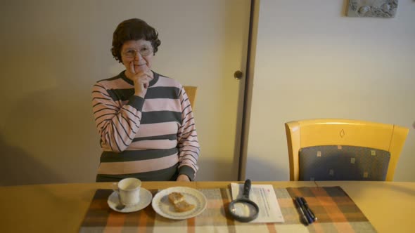 Beautiful Senior Woman Thinking in the Dining Room at Home