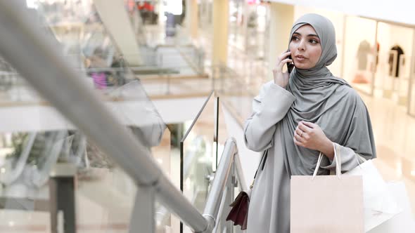 Mixed-race Woman in Hijab Talking on Phone in Mall