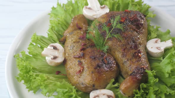 Fried Chicken Thighs Decorated with Mushrooms and Lettuce Rotate on a Plate