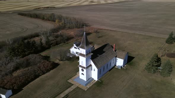 Aerial footage in 4k orbiting an old catholic prairie church in rural Alberta, Canada. While circlin