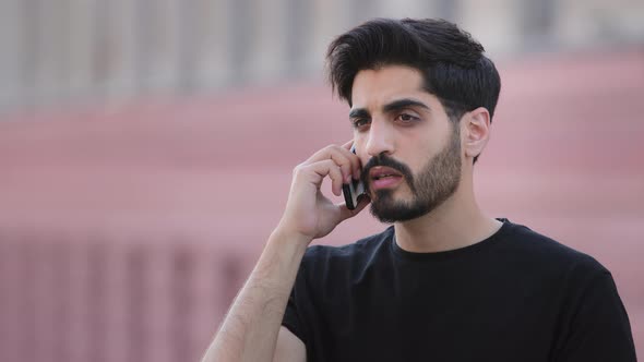 Angry Stressed Bearded Indian Male Businessman Disputing on Phone with Partner