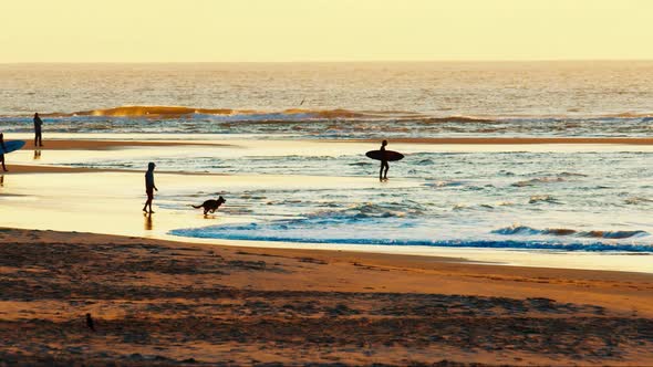 People Walk on the Beach and Meet Sunrise Near the Ocean