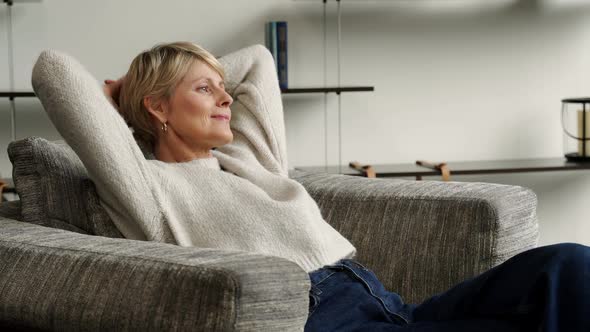 Mature Woman is Resting in a Chair at Home