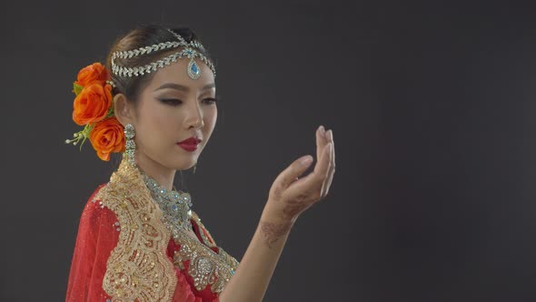 Alluring bride dressed for a traditional Indian wedding blows a kiss to her lover who is out of fram