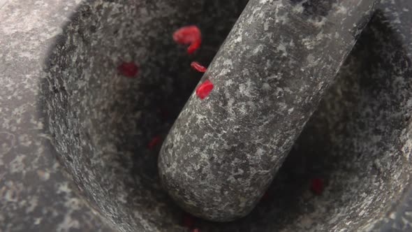 Close-up of Red Dry Barberries Falling Into the Stone Mortar