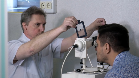 Senior optometrist doing sight testing for patient