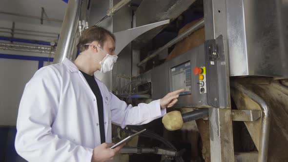 Farmer using automatic milking machine.