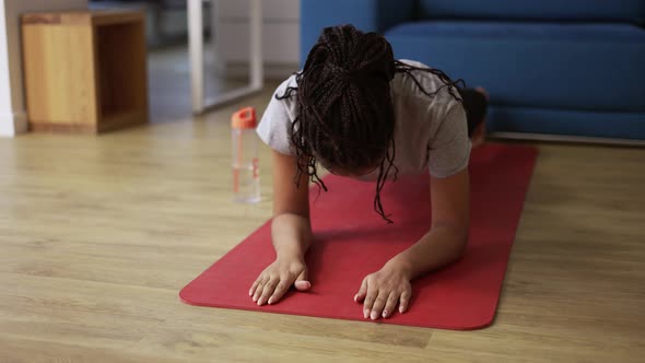 African American Young Sportswoman Doing Plank Exercise at Home