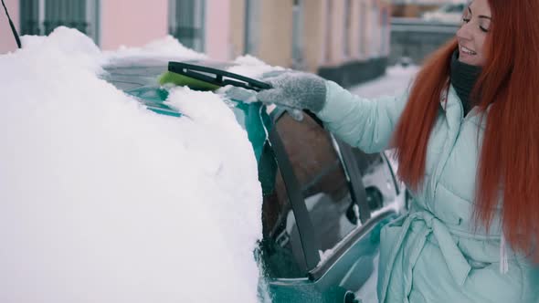 Joyful Woman Cleans Snow From Her Car