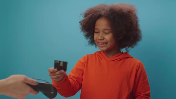 African American girl paying with credit card and contactless NFC terminal.