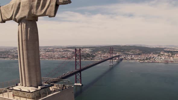 25 de Abril Bridge over Tagus River and the Sanctuary of Christ the King. Aerial pullback shot