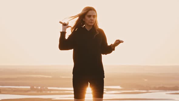 Young Woman in Black Clothes Playing with a Sword on Nature