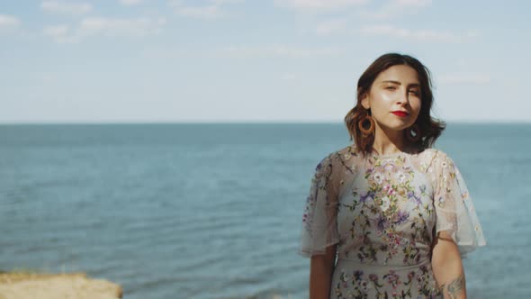 Attractive Woman with Red Lips Touches Her Curly Hair Walk Turn Around and Looking at Camera Slow