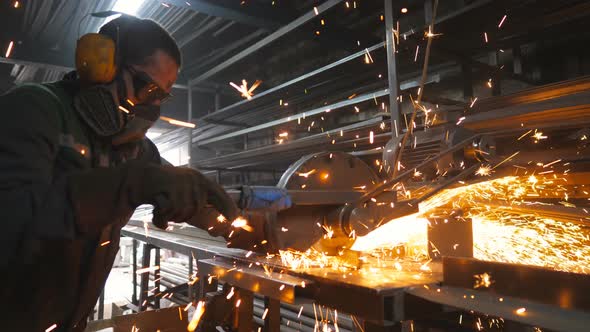 Craftsman Sawing Metal with Disk Grinder in Workshop