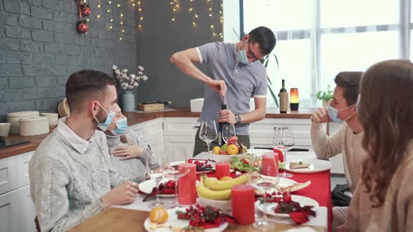 A Man Opens a Bottle of Red Wine in the Company of Friends