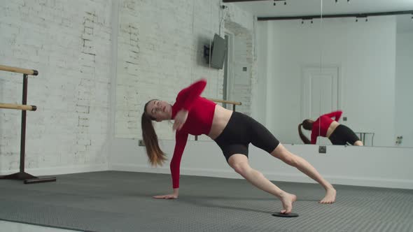 Sporty Fit Woman Doing Side Plank with Fitness Disc