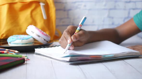 Child Boy Drawing with Colored Pencil on a Page