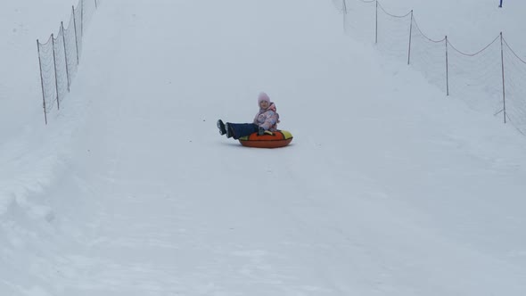 Little Girl Riding on a Snow Tube in Winter