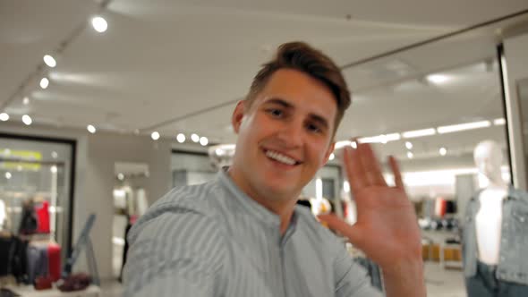 A Man Takes a POV Selfie As He Walks Through a Clothing Store