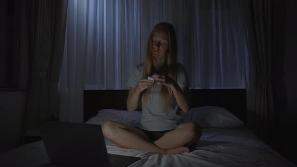 A Woman at Night Turns on a Meditation Relaxation Application on Her Computer to Relax Before Going