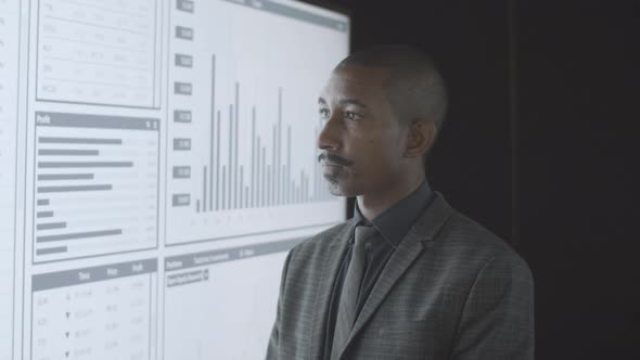 Pensive Black Professional Investor Analyzing Statistics