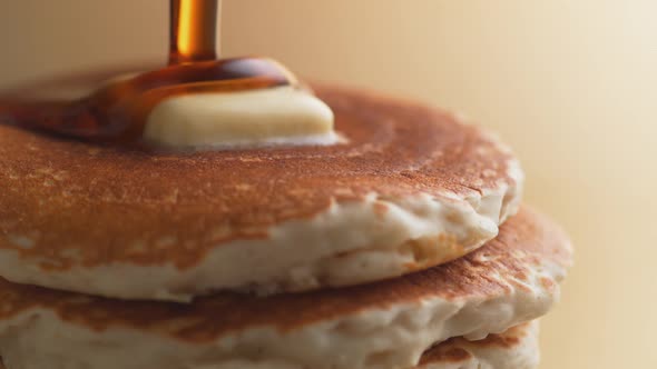 Pouring honey on stack of pancakes. Slow Motion.