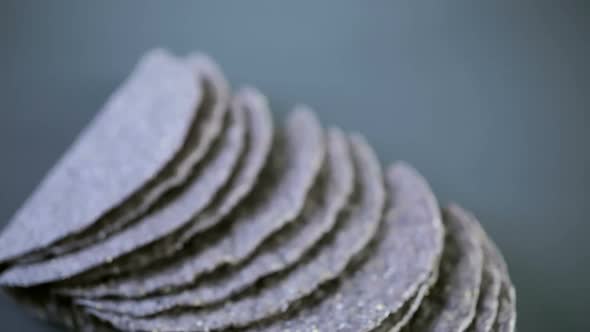 Blue corn taco shells on a gray background.