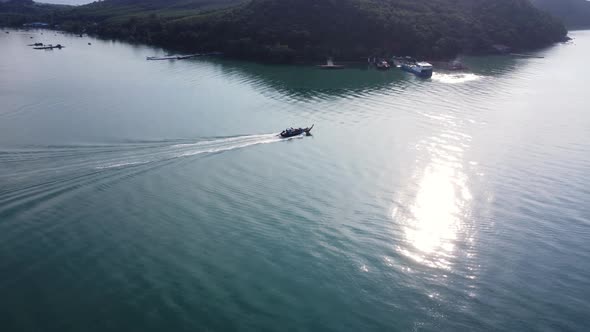 Aerial view from a drone of Thai traditional longtail fishing boats sailing in the sea.